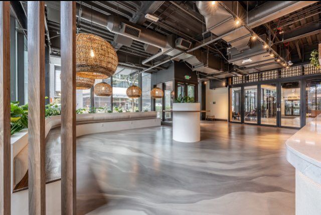 A large empty room with a lot of windows and a table in the middle.