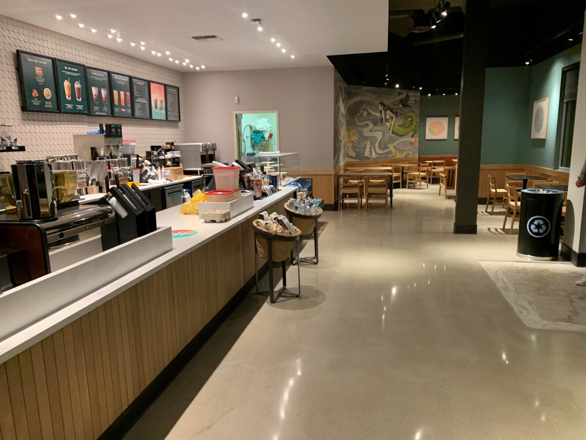 The inside of a starbucks coffee shop with a counter and tables.