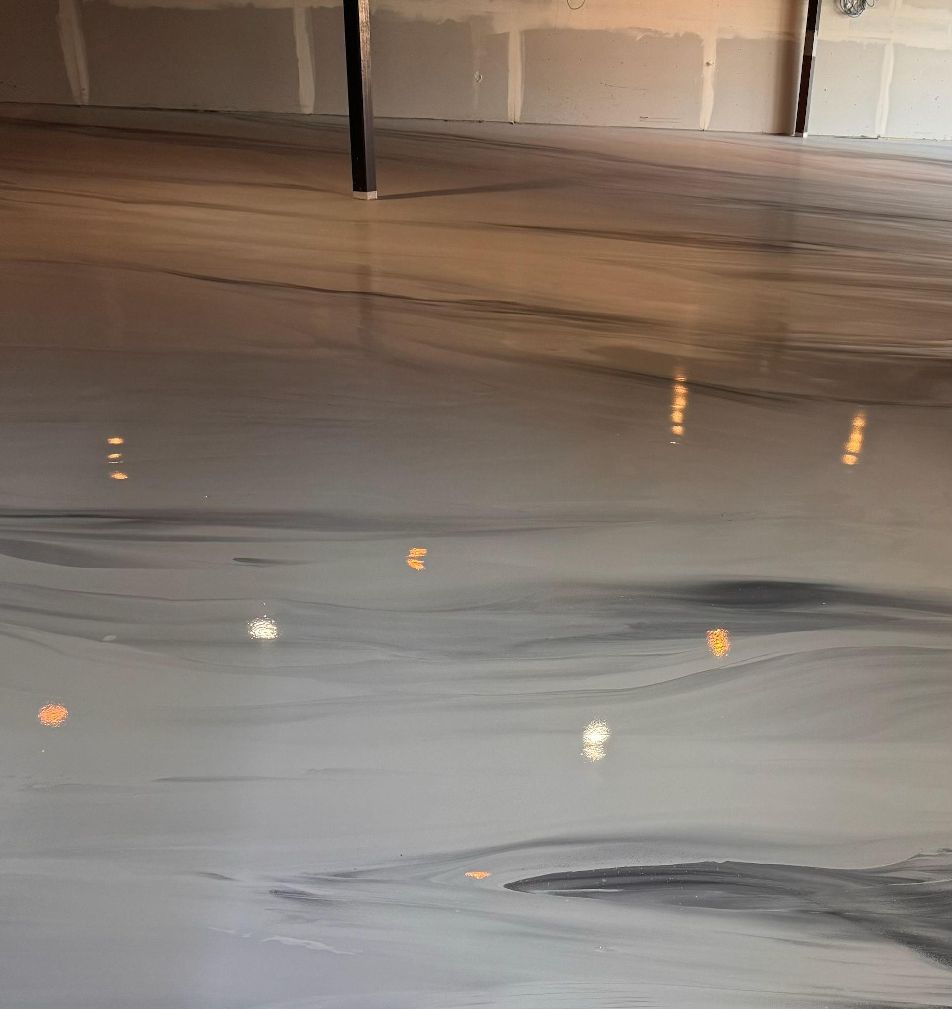 A close up of a gray and black epoxy floor in a basement.