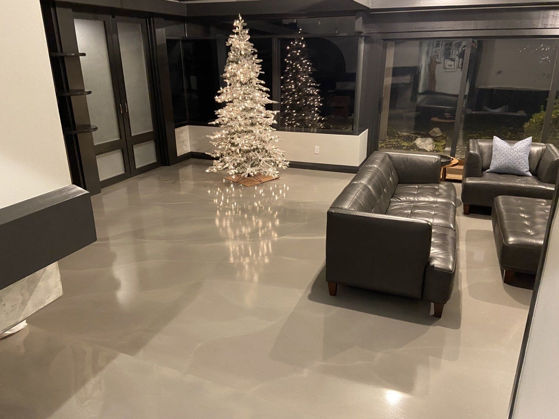 There is a christmas tree in the middle of the living room.