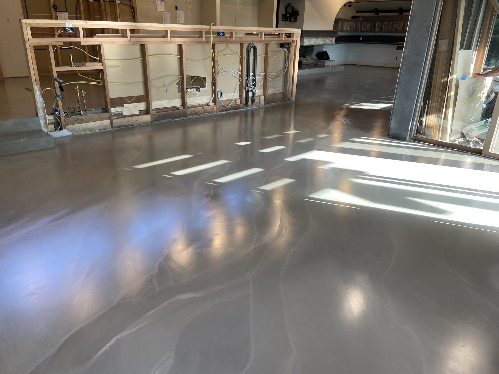 A shiny concrete floor in a room under construction.