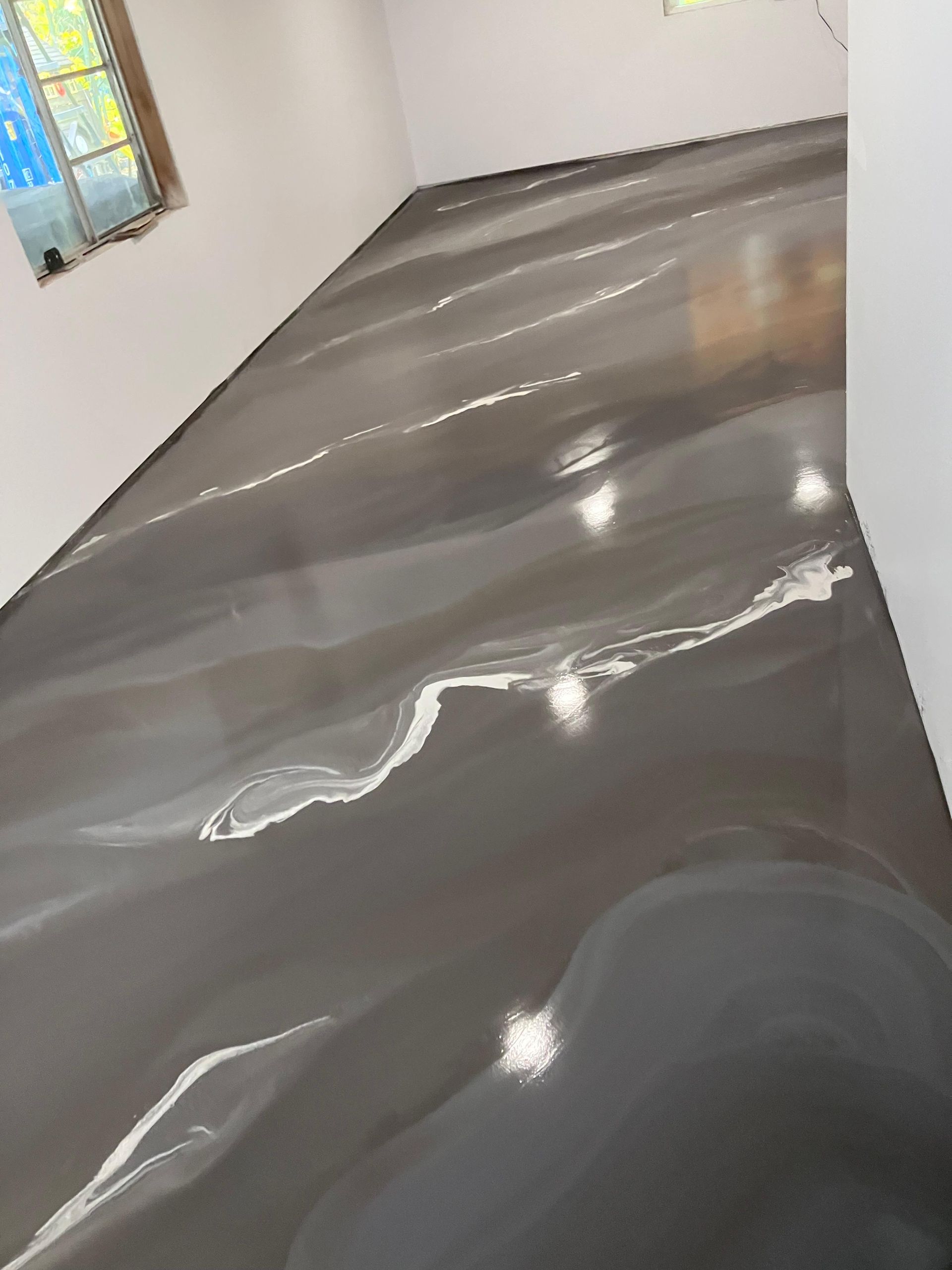 A room with a black floor and a stained glass window.