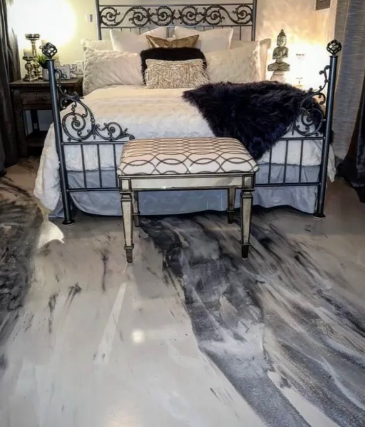 A bedroom with a bed and a bench on the floor.