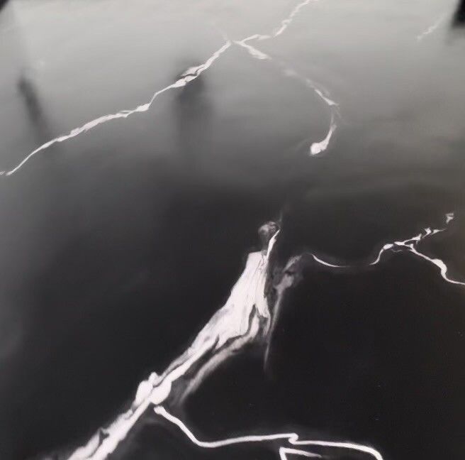 A black and white photo of a lightning bolt on a black surface.