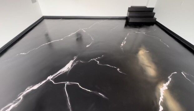 A black and white marble floor with stairs in the background