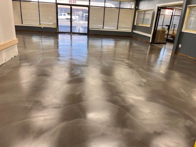 A large room with a shiny concrete floor and a lot of windows.