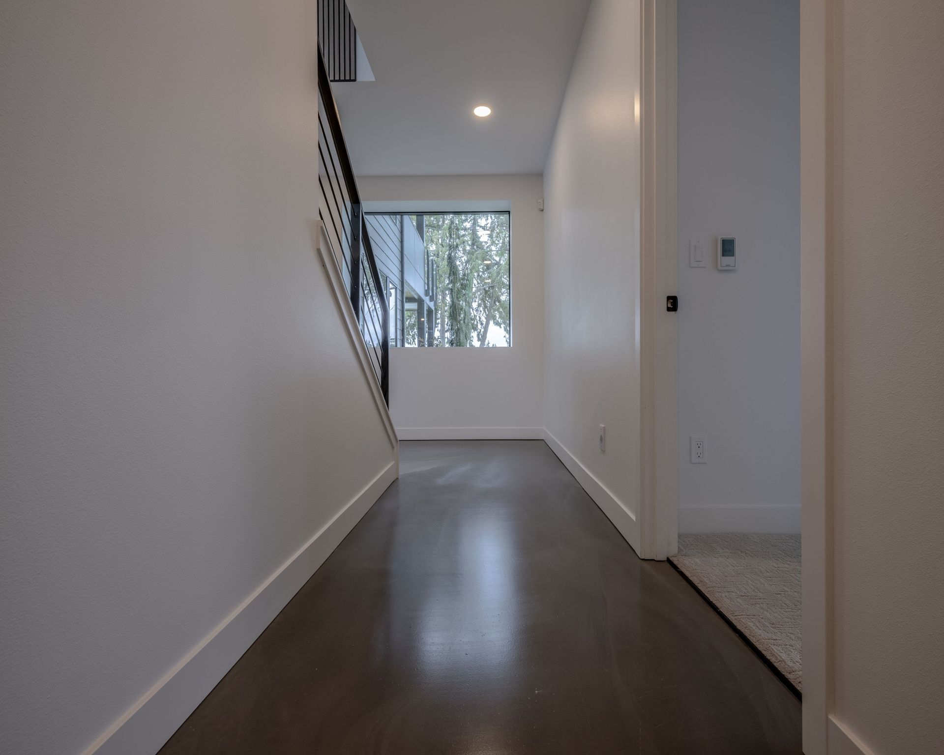 An empty hallway with stairs and a window