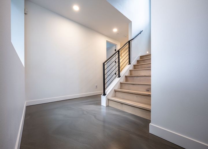 A hallway with stairs and a railing in a house.