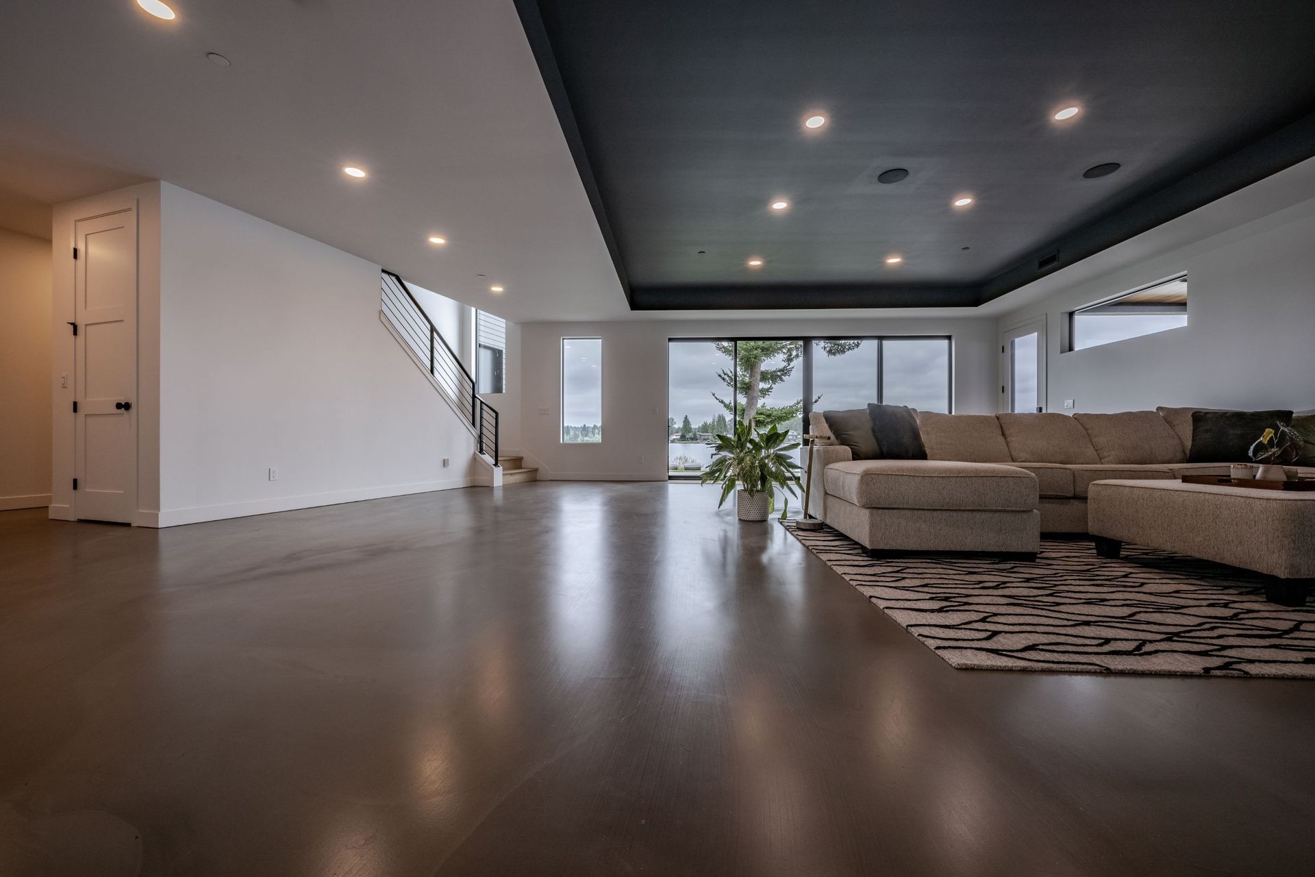A living room with a couch , rug , and stairs.
