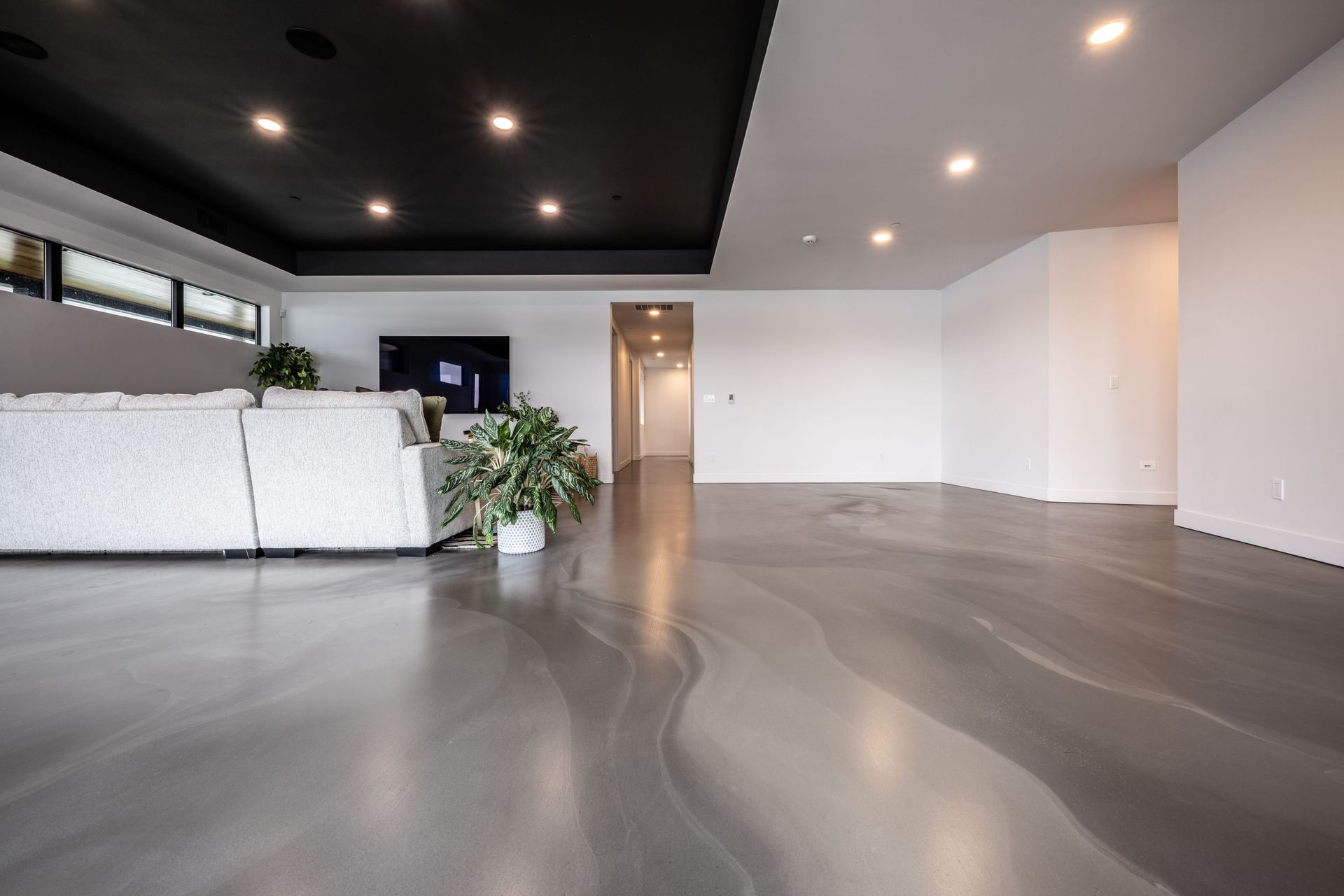 A living room with a couch and a television on the wall.