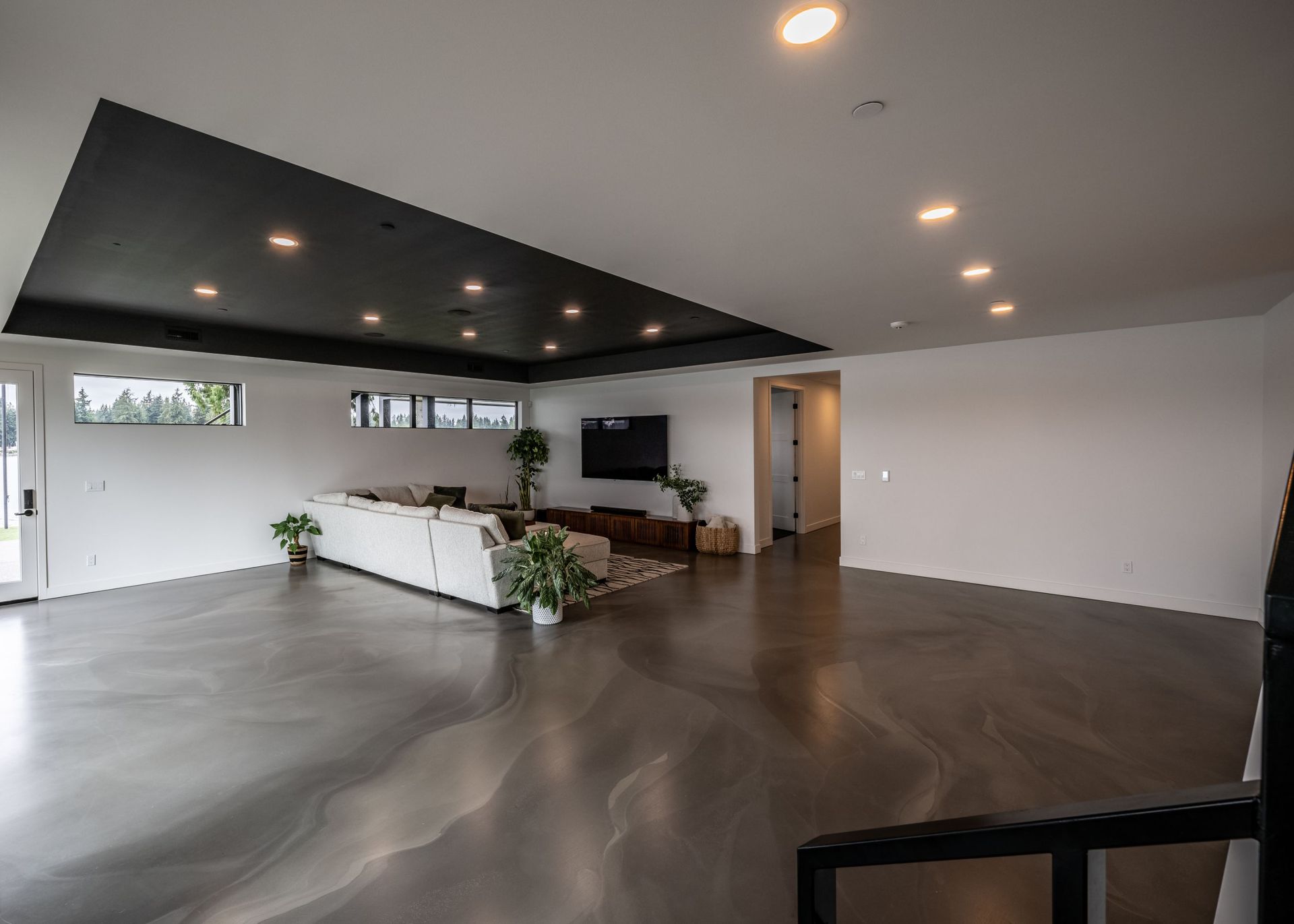 A living room with a couch and a television on the wall.