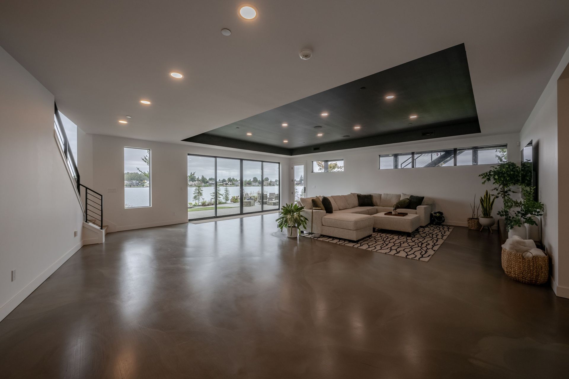 A large empty living room with a couch and stairs.