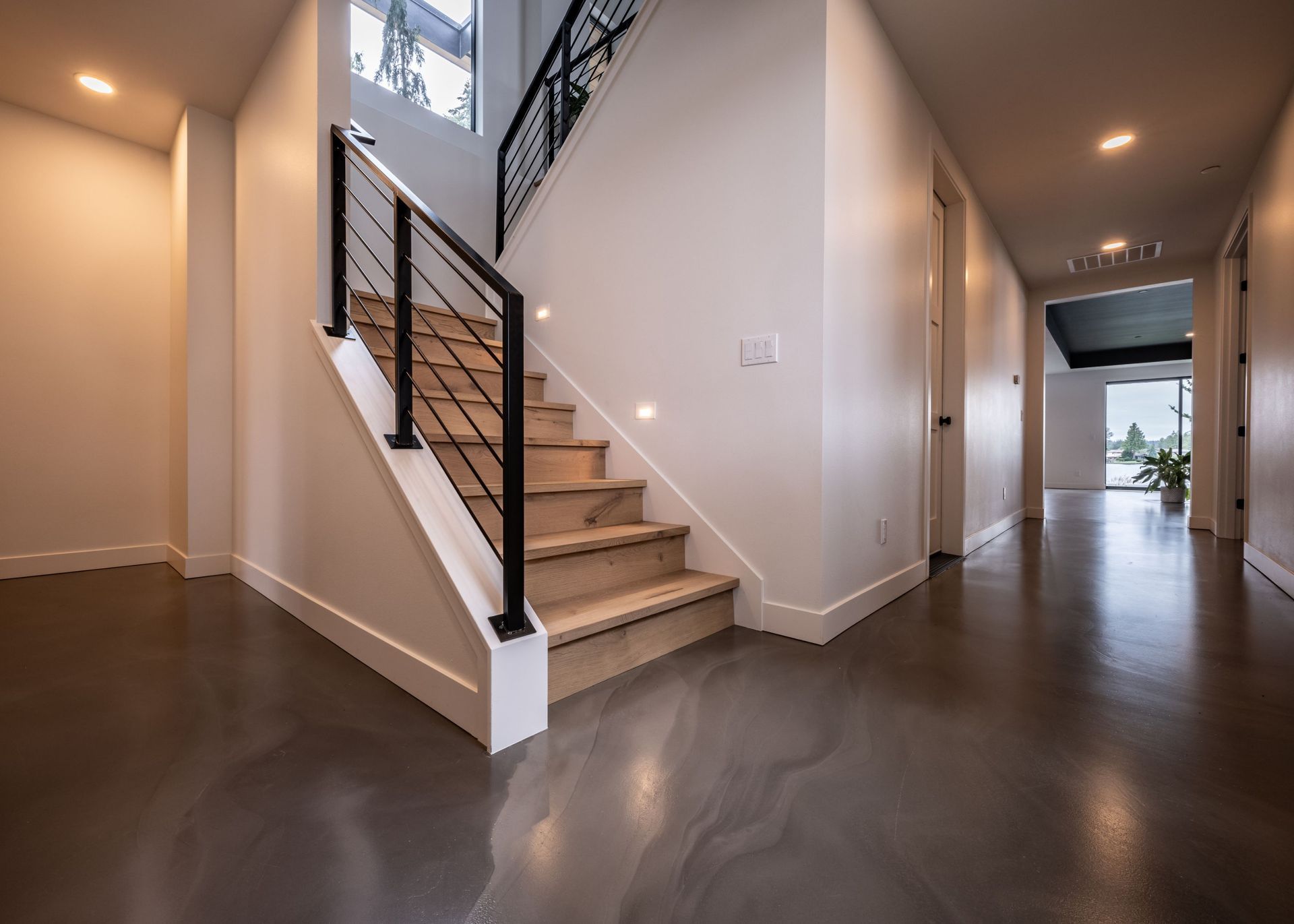 A hallway with stairs leading up to the second floor of a house.