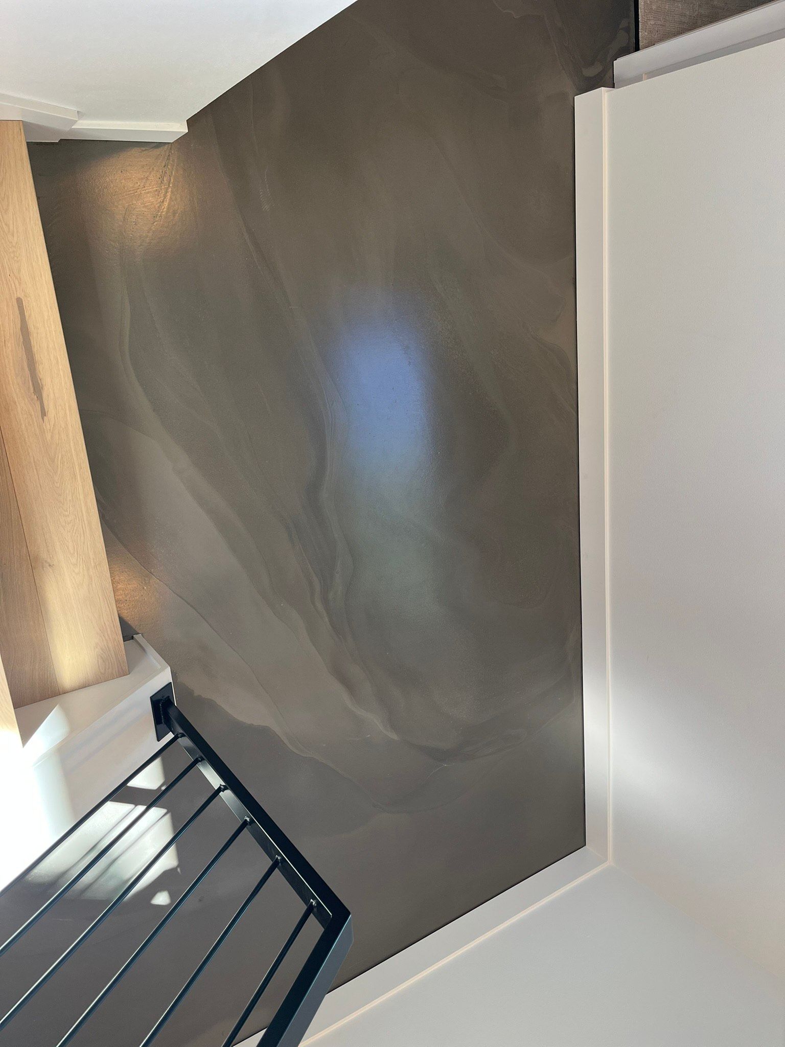 A staircase with a railing and a wall in a room.