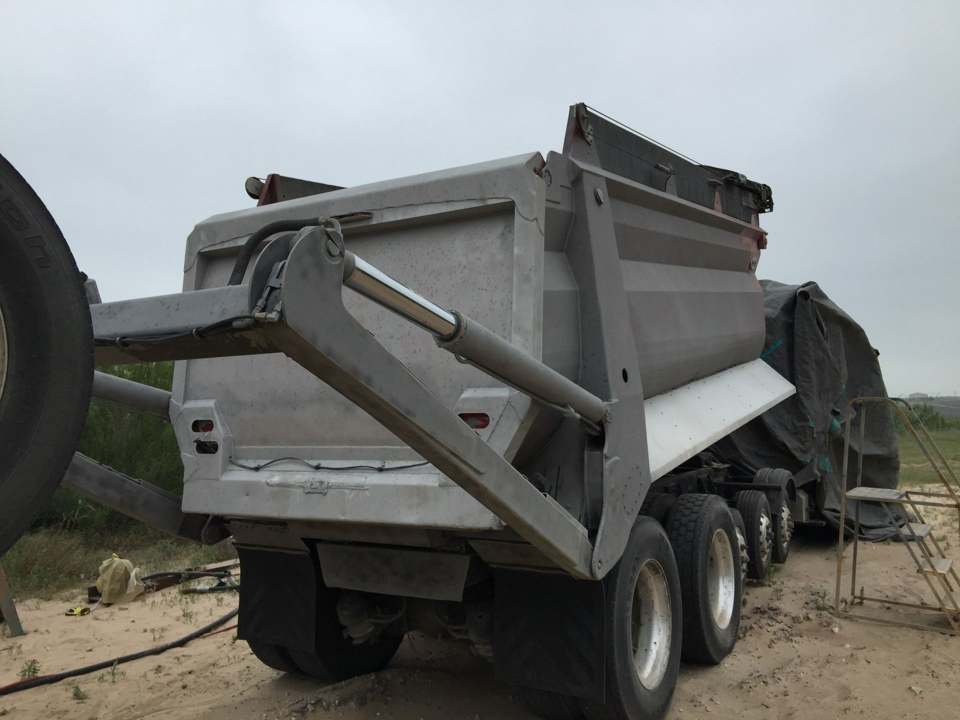 A large dump truck is parked in a dirt field