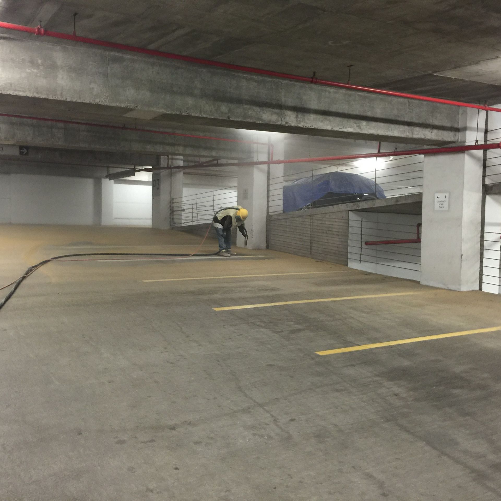 A man in a hard hat is working in a parking garage