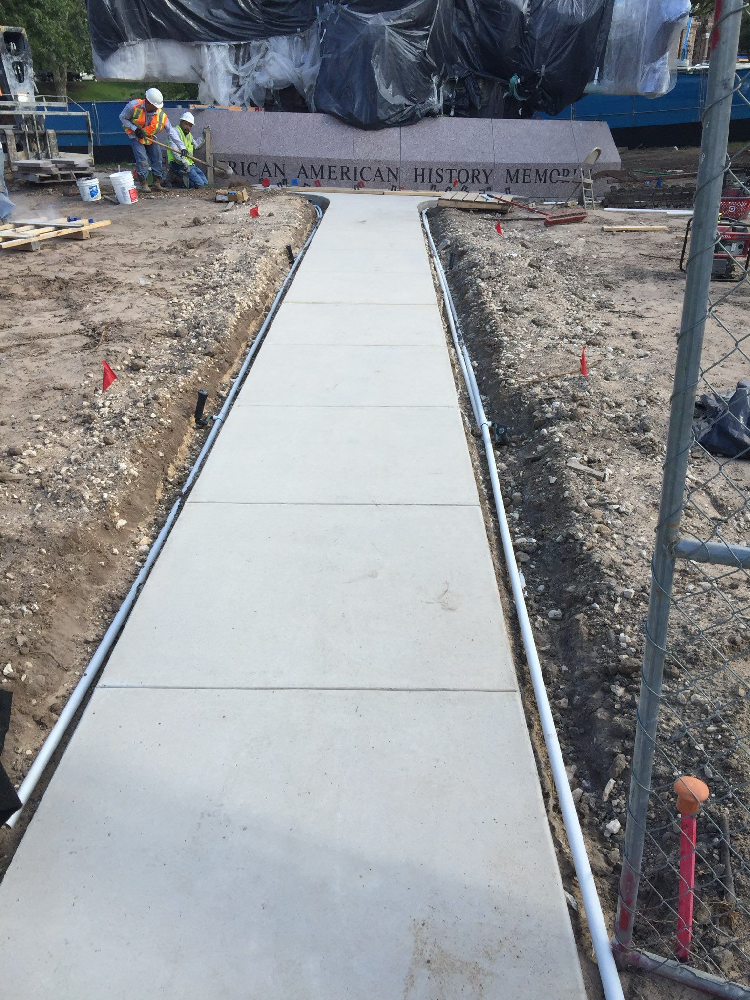 A concrete walkway is being built in a construction site.