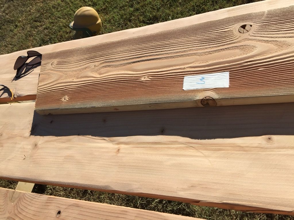 A piece of wood is sitting on top of a wooden table.