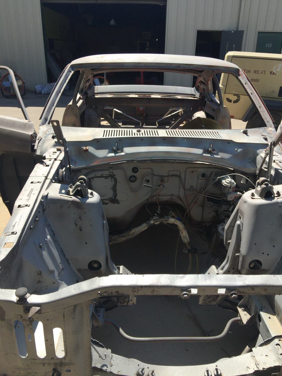 A car is being dismantled in a garage.