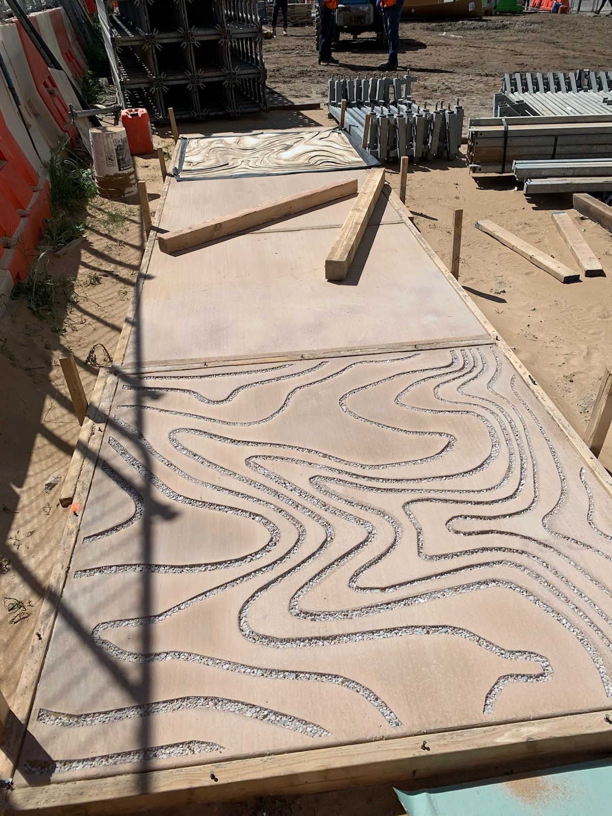 A large piece of wood with a pattern on it is sitting on top of a dirt field.