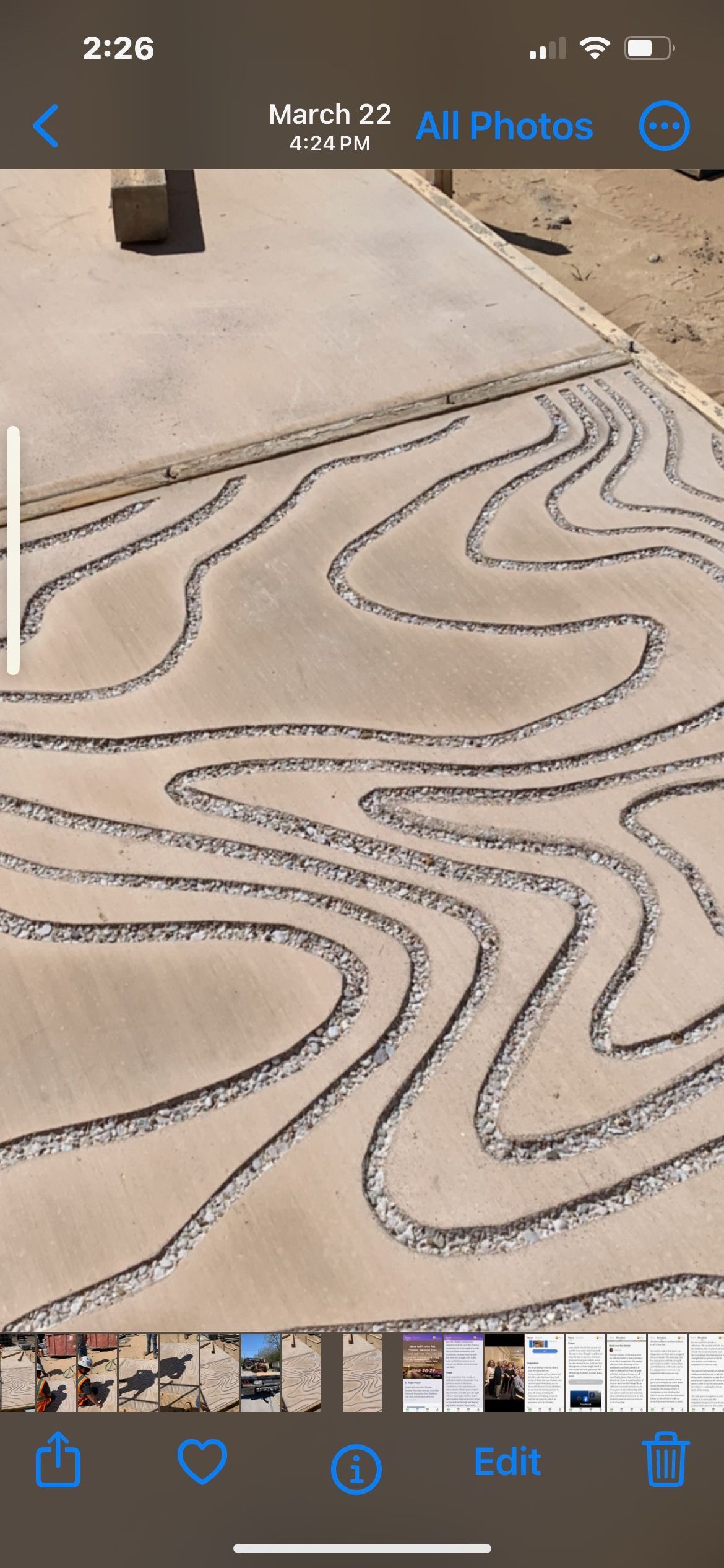 A phone screen shows a picture of a concrete driveway.