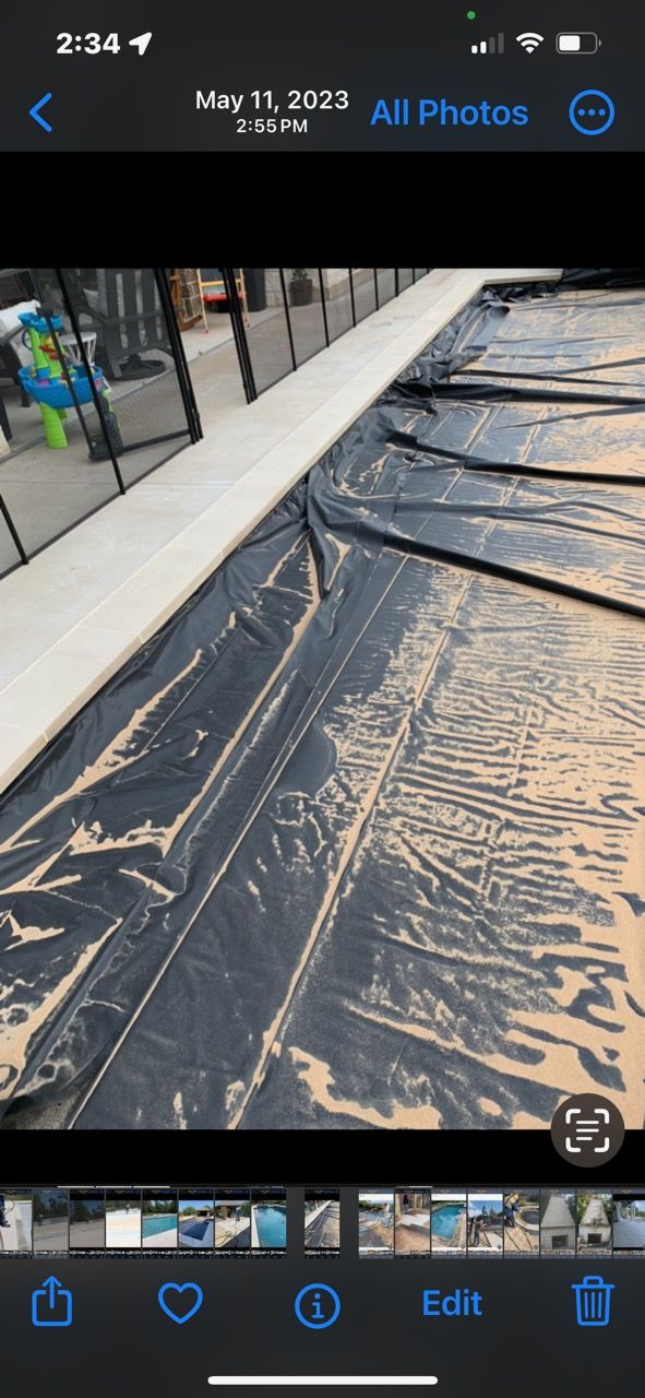 A phone screen shows a picture of a swimming pool being built.