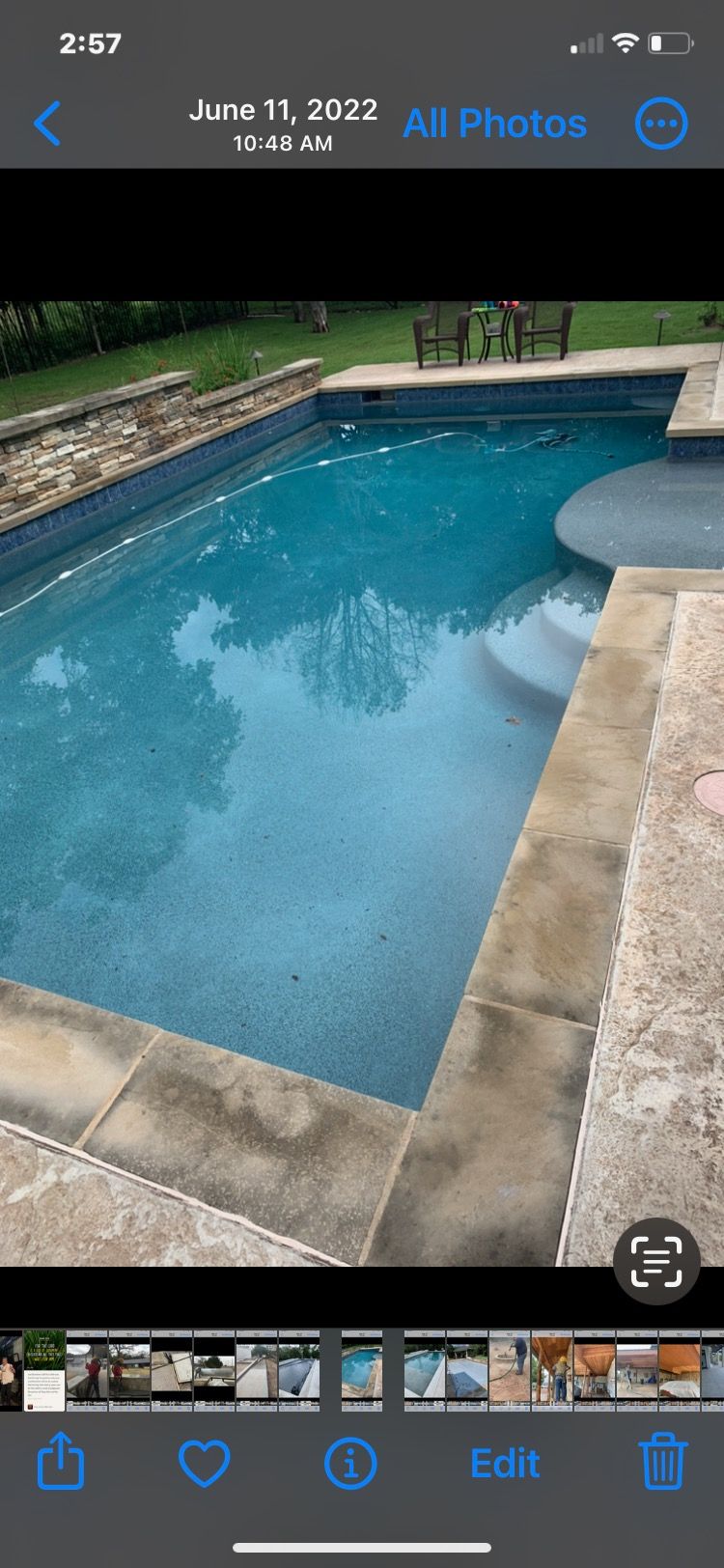 A phone screen shows a picture of a swimming pool.