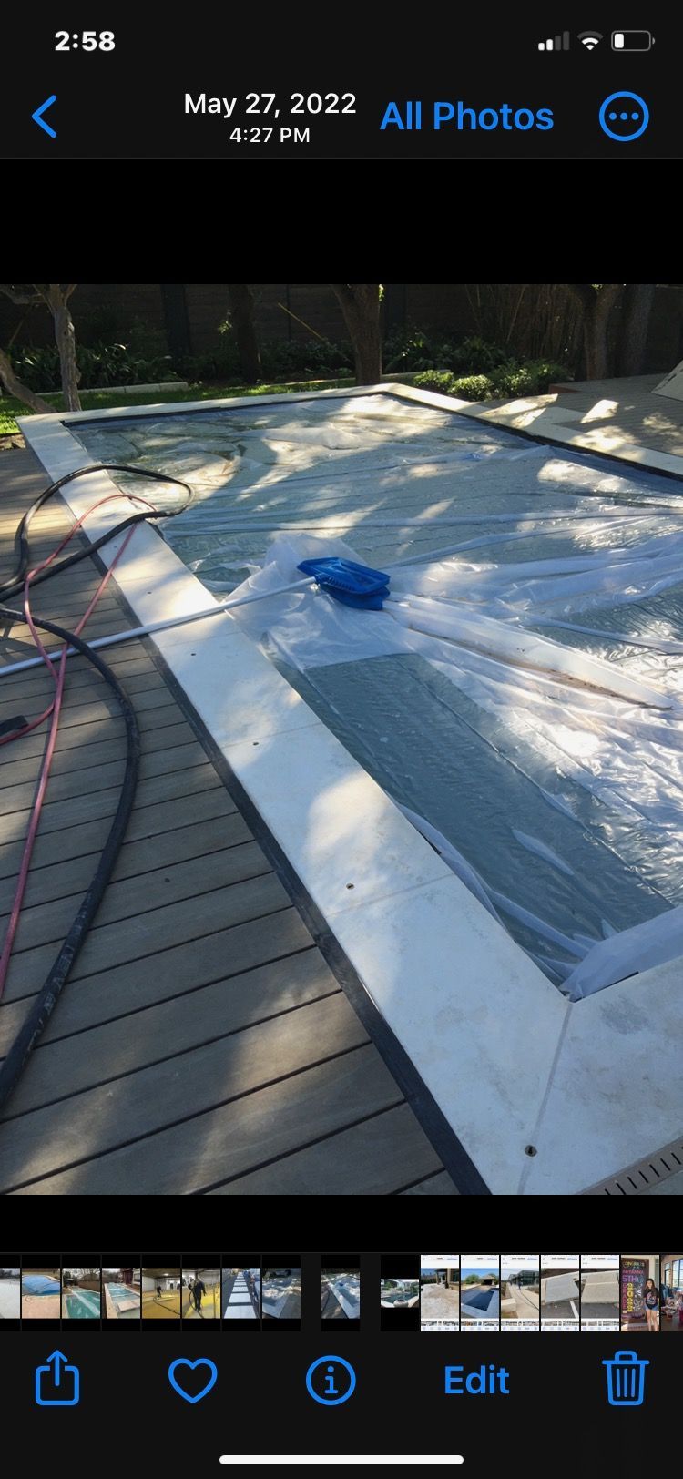 A phone screen shows a picture of a swimming pool being cleaned.