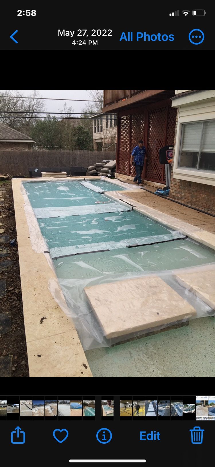 A phone screen shows a swimming pool covered in plastic.