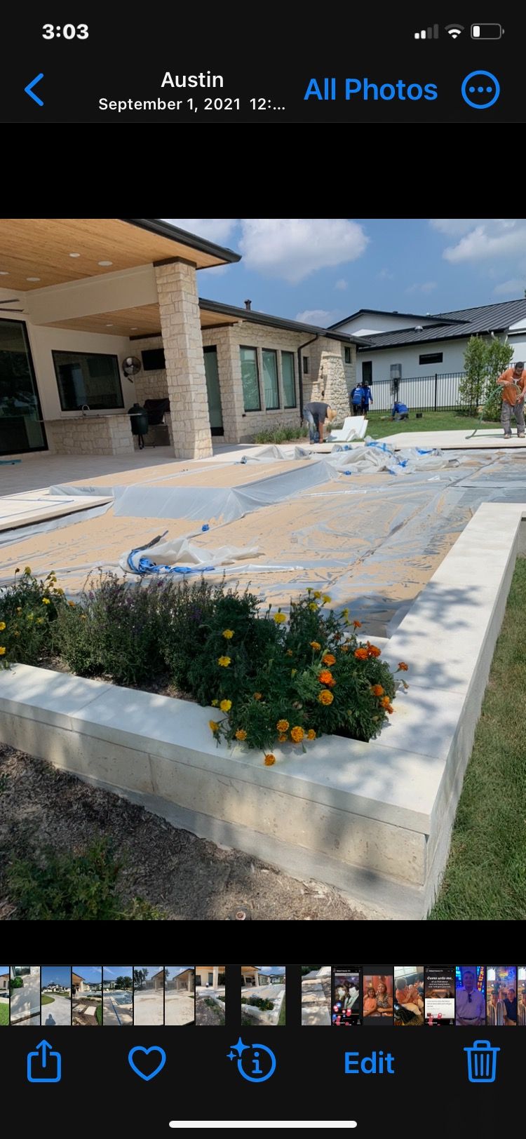 A phone screen shows a picture of a house under construction.