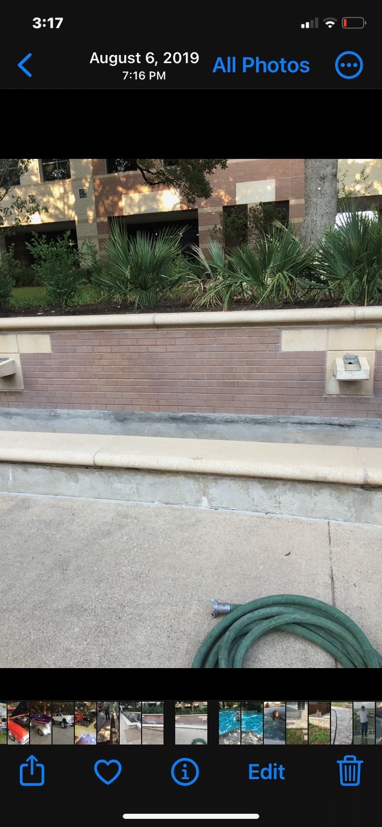 A phone screen shows a picture of a hose next to a brick wall.