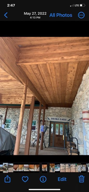 A phone screen shows a picture of a wooden ceiling.