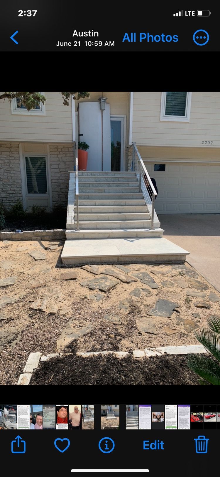 A phone screen shows a picture of a house with stairs leading up to it.