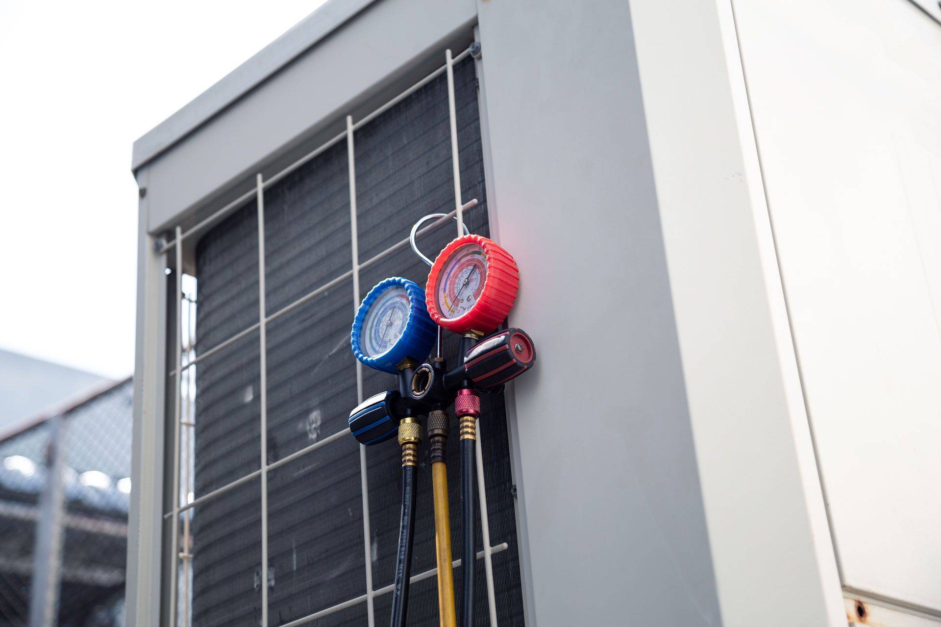 A couple of gauges hanging on the side of a building