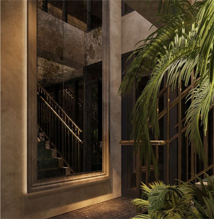 A large mirror is hanging on a wall next to a palm tree and stairwell at the Harbour Club in Miami Beach.