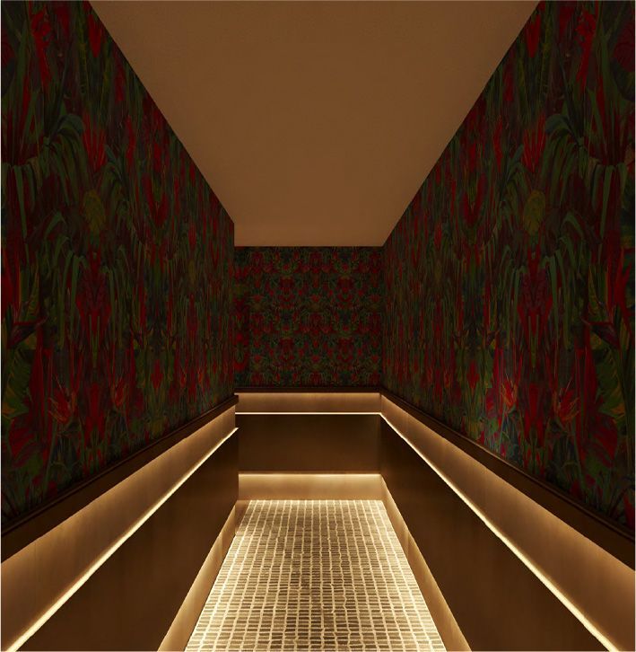 A narrow hallway with a floral wallpaper on the wall