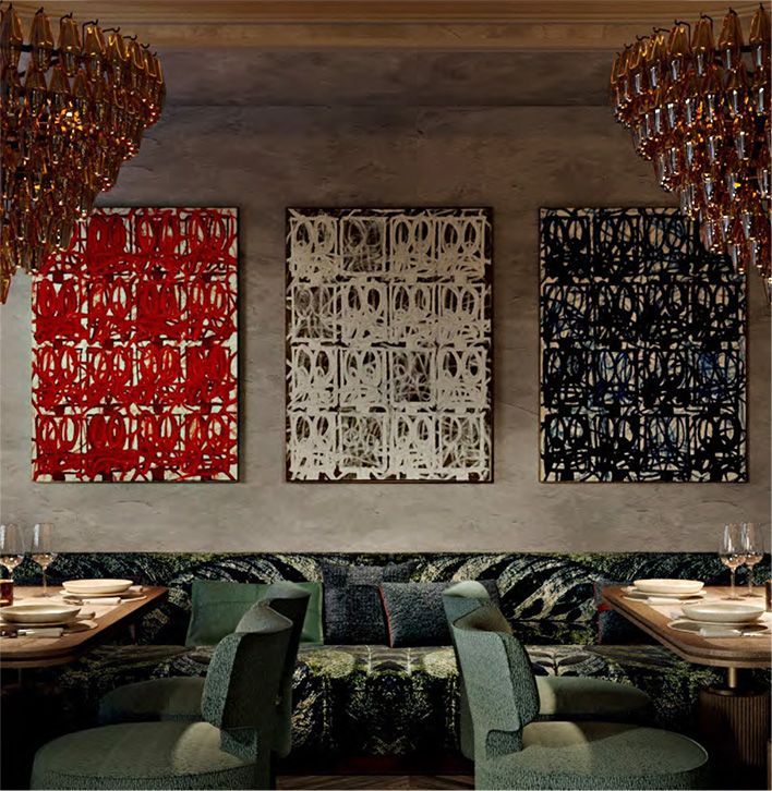 A dining room with a couch and three paintings on the wall