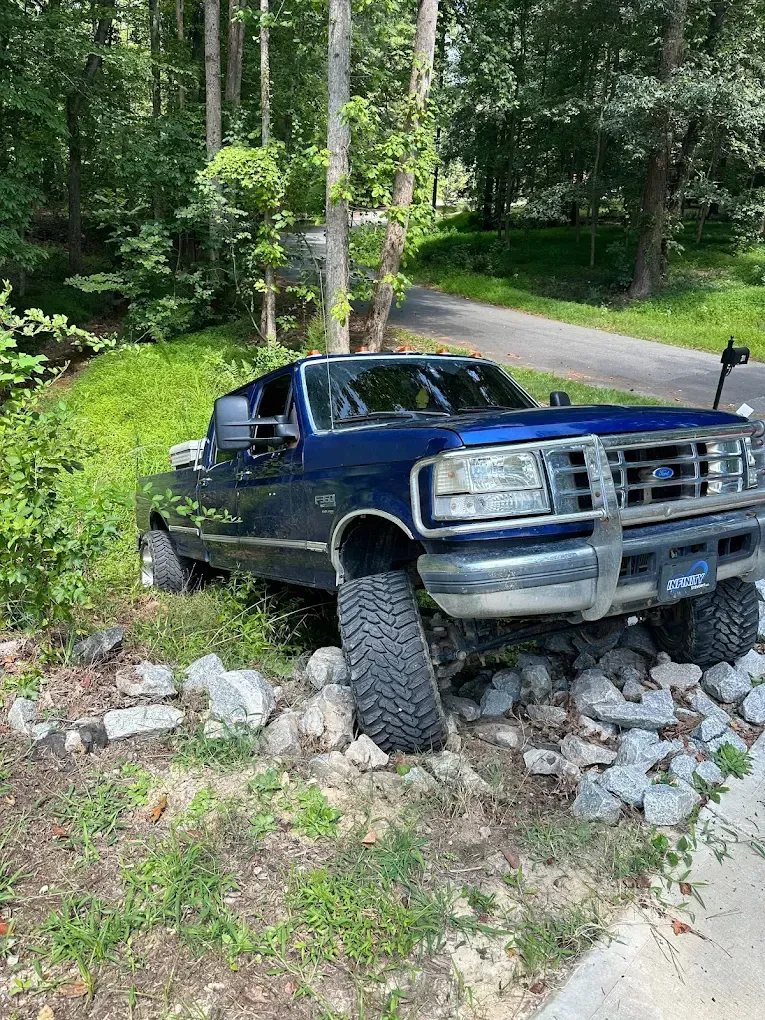 A blue truck is parked on the side of the road.