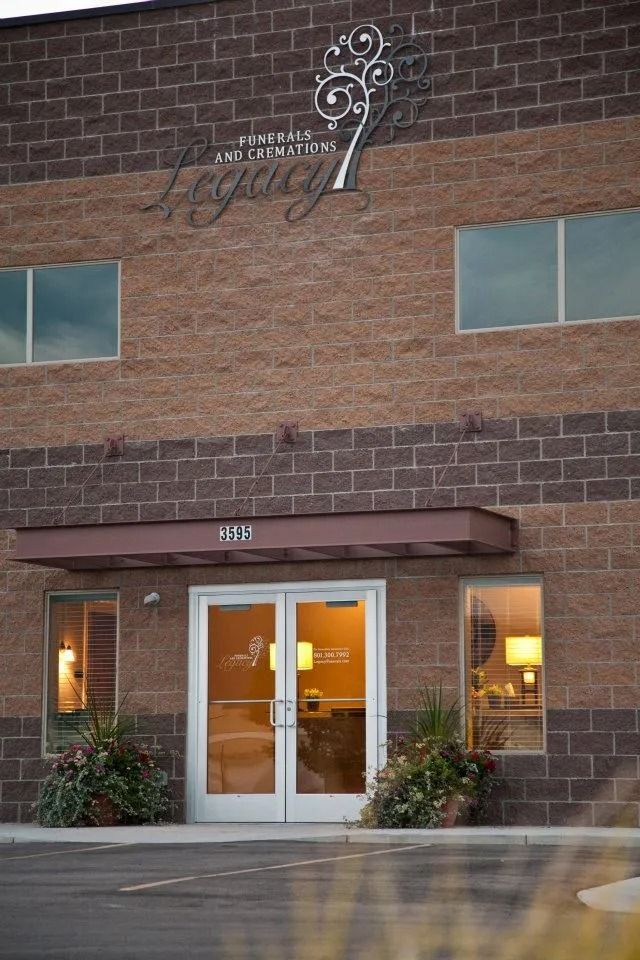 Brick building entrance with double glass doors and a decorative sign above the doorway