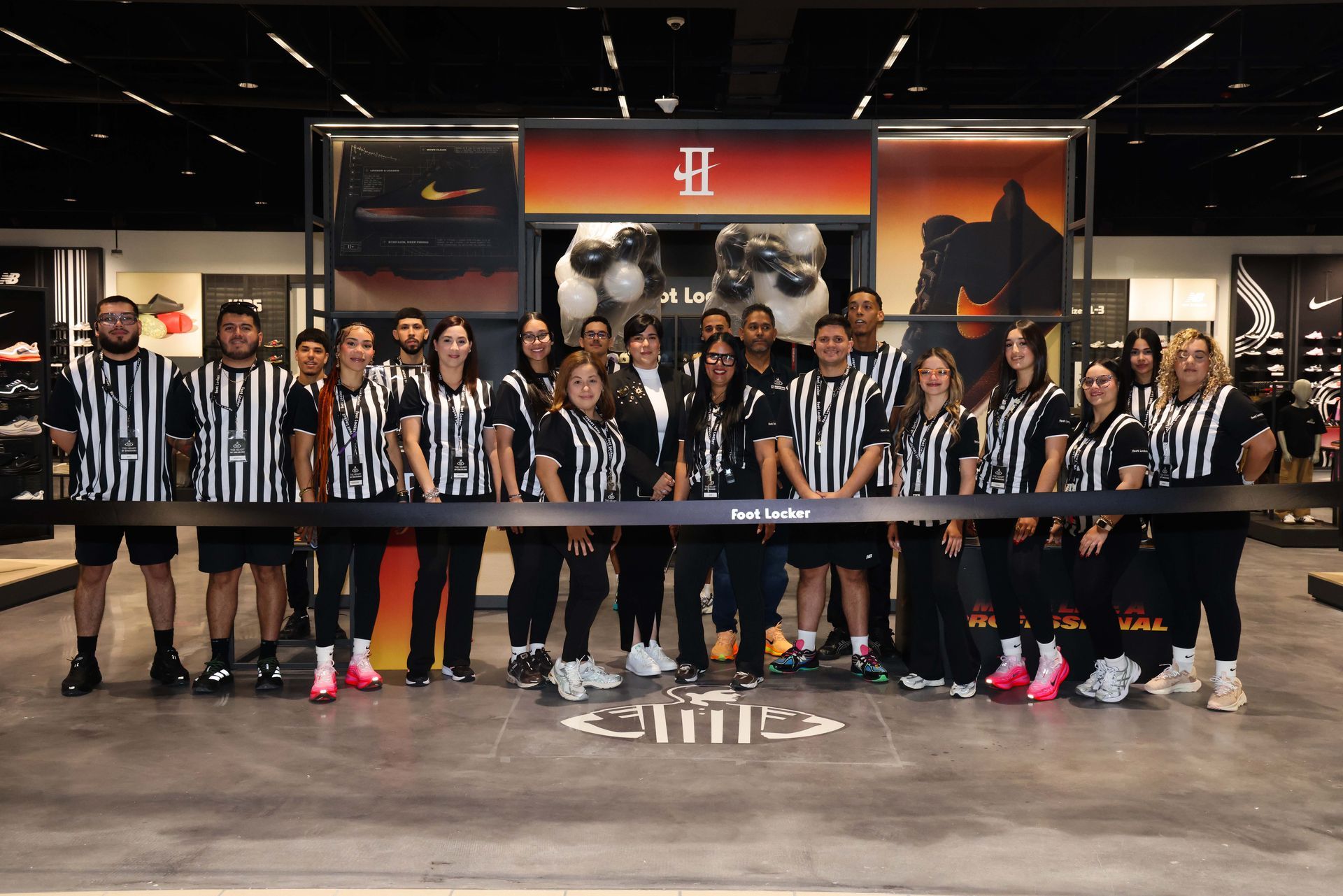 Aerial view of a shopping center with various stores, including Costco and Popeyes, against a mountain backdrop.