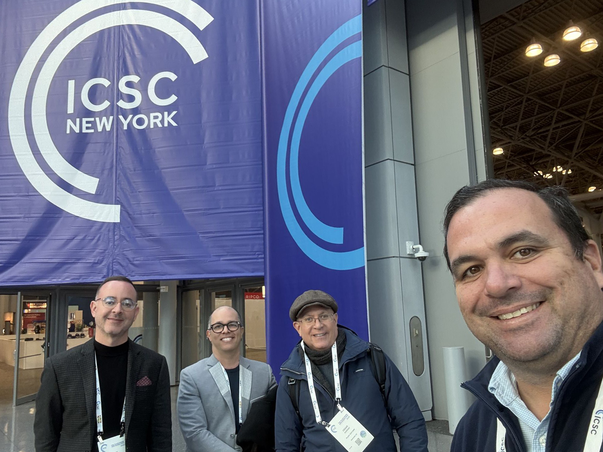 Aerial view of a shopping center with various stores, including Costco and Popeyes, against a mountain backdrop.