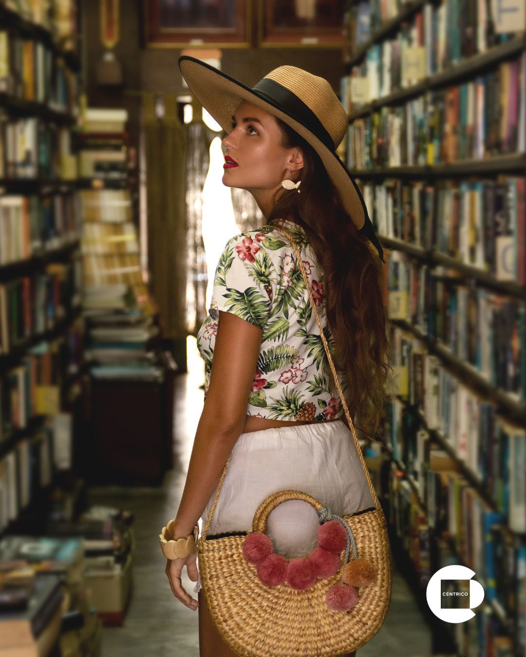 Three smiling people, embracing. One has a tattoo, others wearing casual shirts. Sky background.