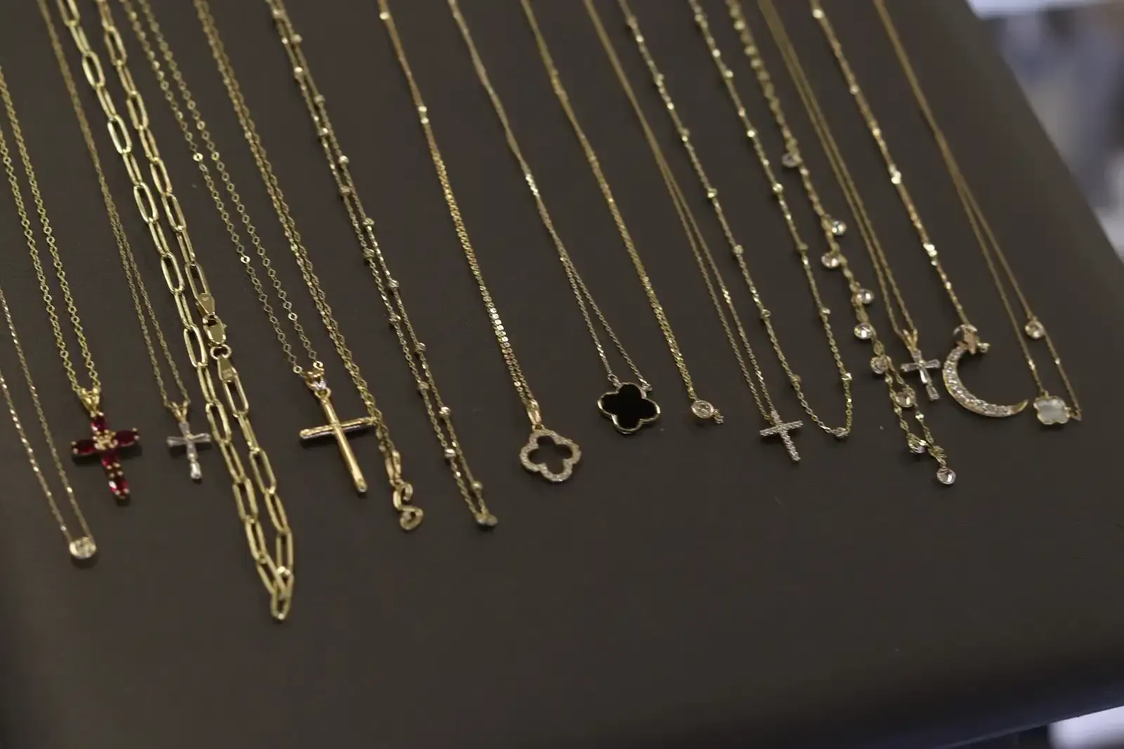 A variety of gold necklaces are displayed on a table