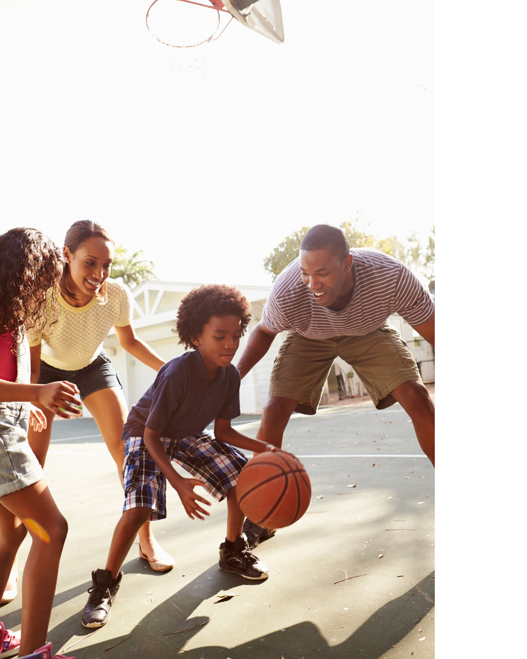 Family on a yellow and black ramp. Man with children, and older kids sitting above. All wear casual clothing.