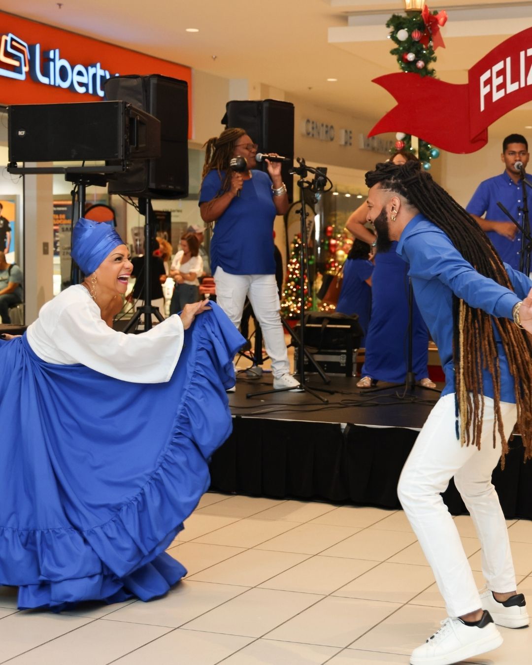 Chef in red shirt watches flames erupt from a grill in a restaurant kitchen.