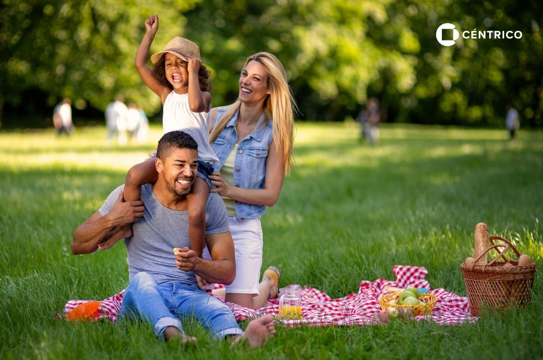 A family picnics on grass with a holiday schedule listed below, showing opening hours for Semana Santa.