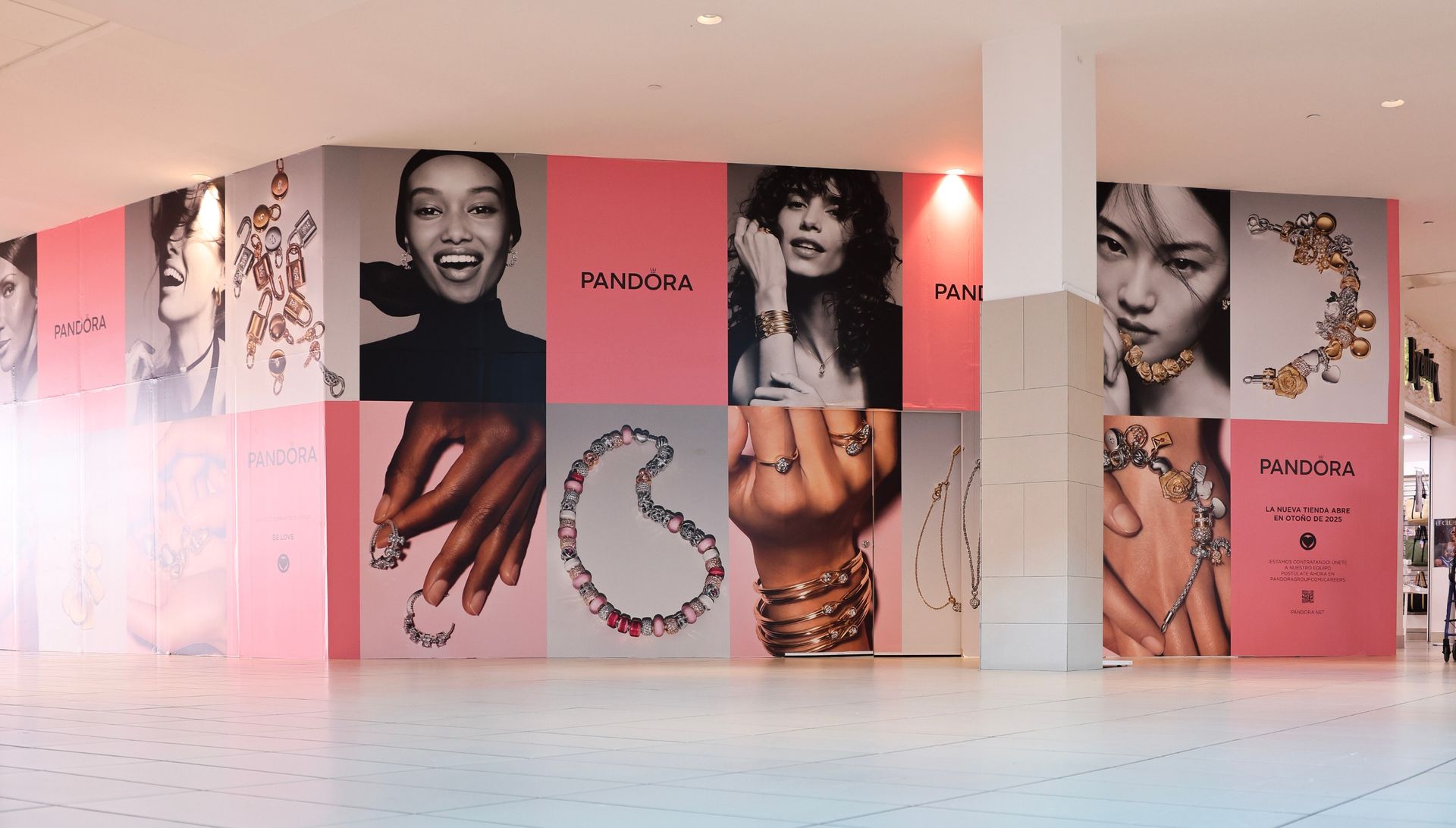 Pink Pandora store display featuring models and jewelry.
