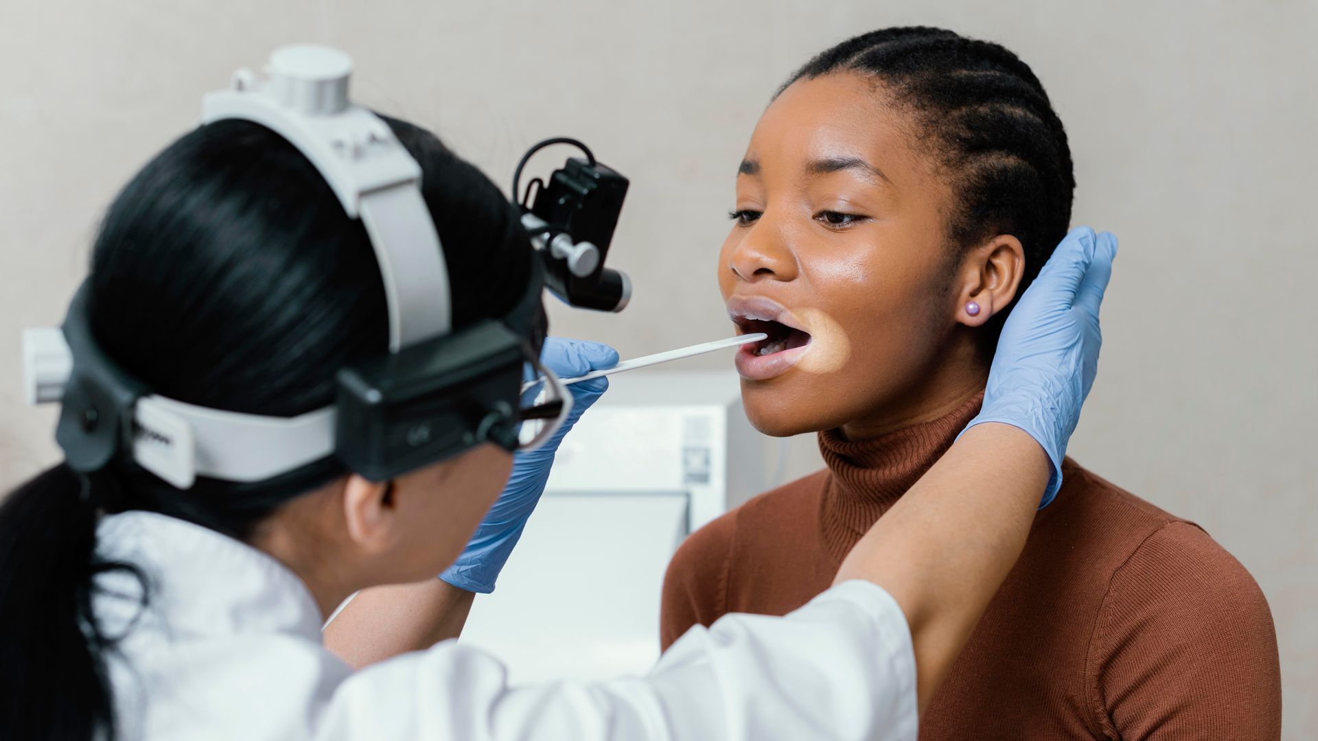 A speech pathologist checks the throat health of a patient as part of speech pathology jobs in Australia
