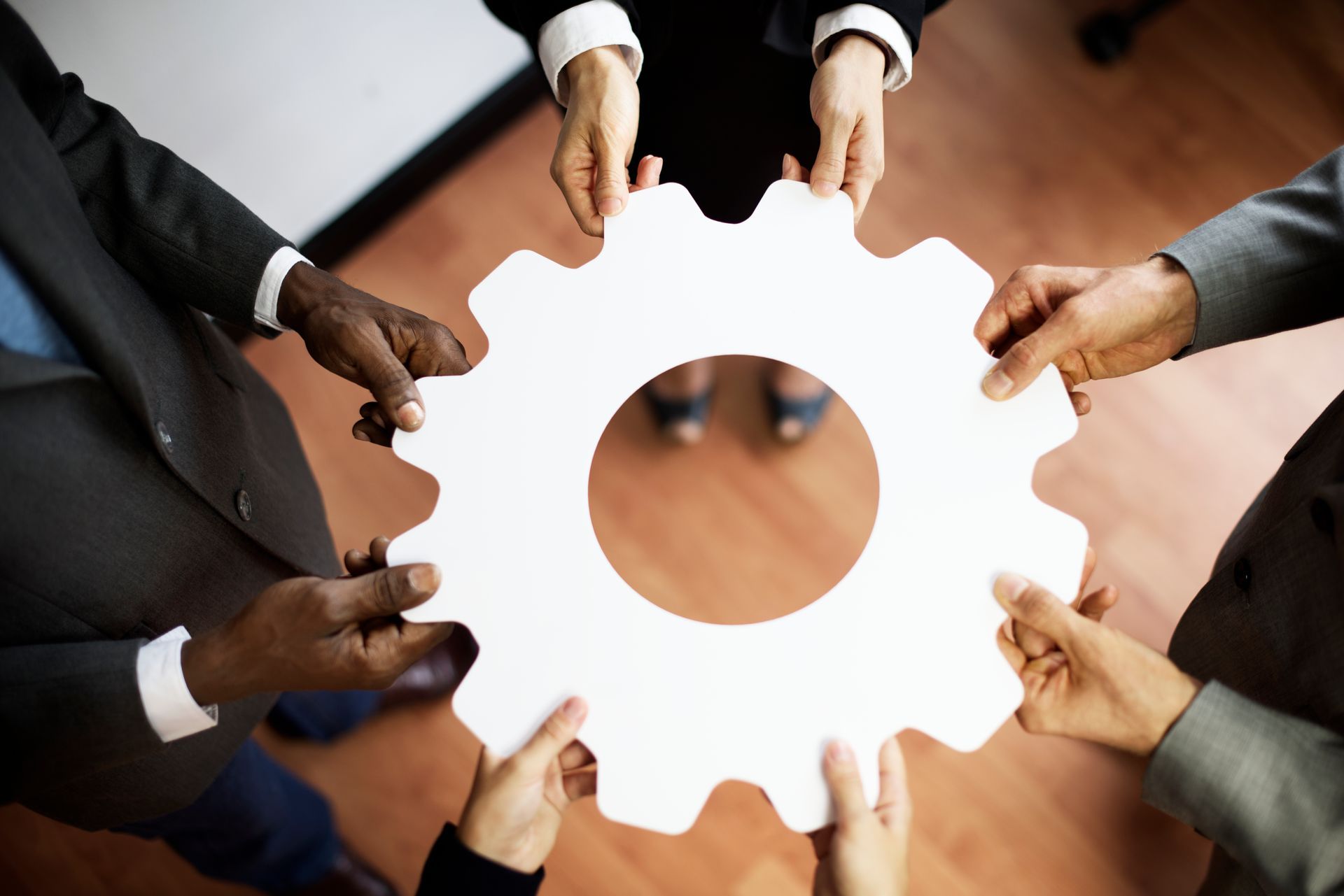 Support coordination team holding a symbolic gear to represent collaboration