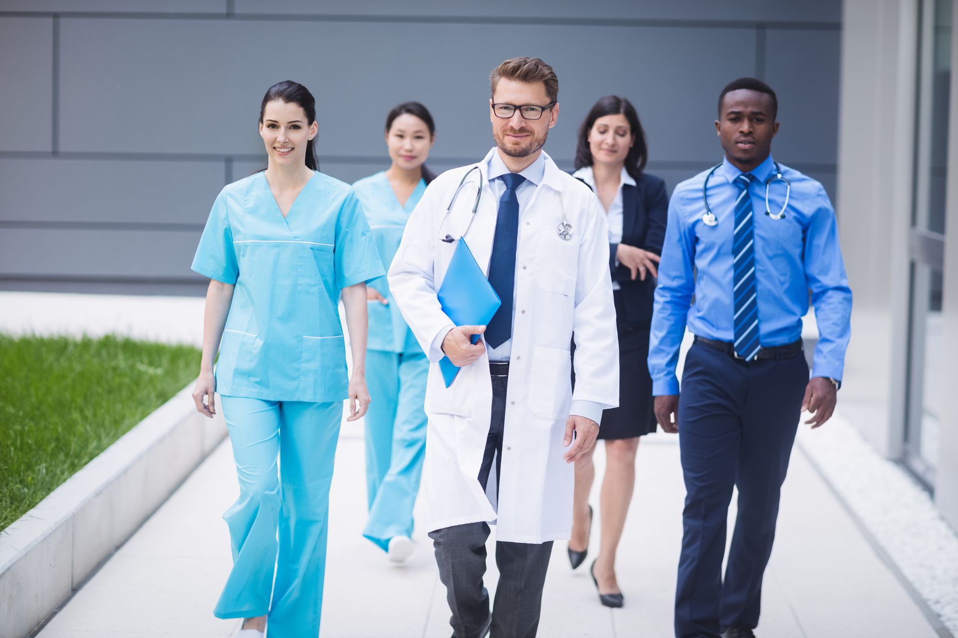 Allied health professionals walking together outside a medical facility